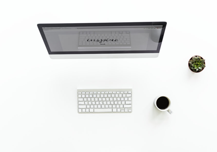 Leerer Arbeitsplatz mit Computer, Kaffee und Kaktus